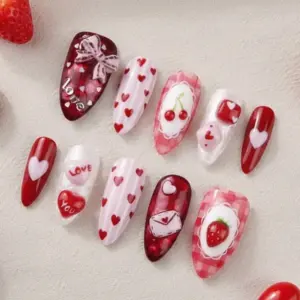 3D Valentine's Day press on nails with cherry charm, strawberry charm, love letter envelope, lace bow, heart scatter and plaid designs in red and pink surrounded by real strawberries