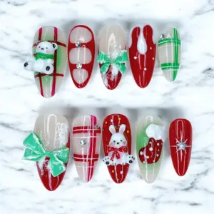 3D Christmas press on nails with polar bear, bunny, green bow, red plaid and Christmas stocking charms on red and white base