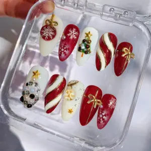Red and gold Christmas press on nails with 3D gem Christmas tree, ornament ball charm, gold bow, candy cane stripes, snowflakes and pearl accents in clear nail box