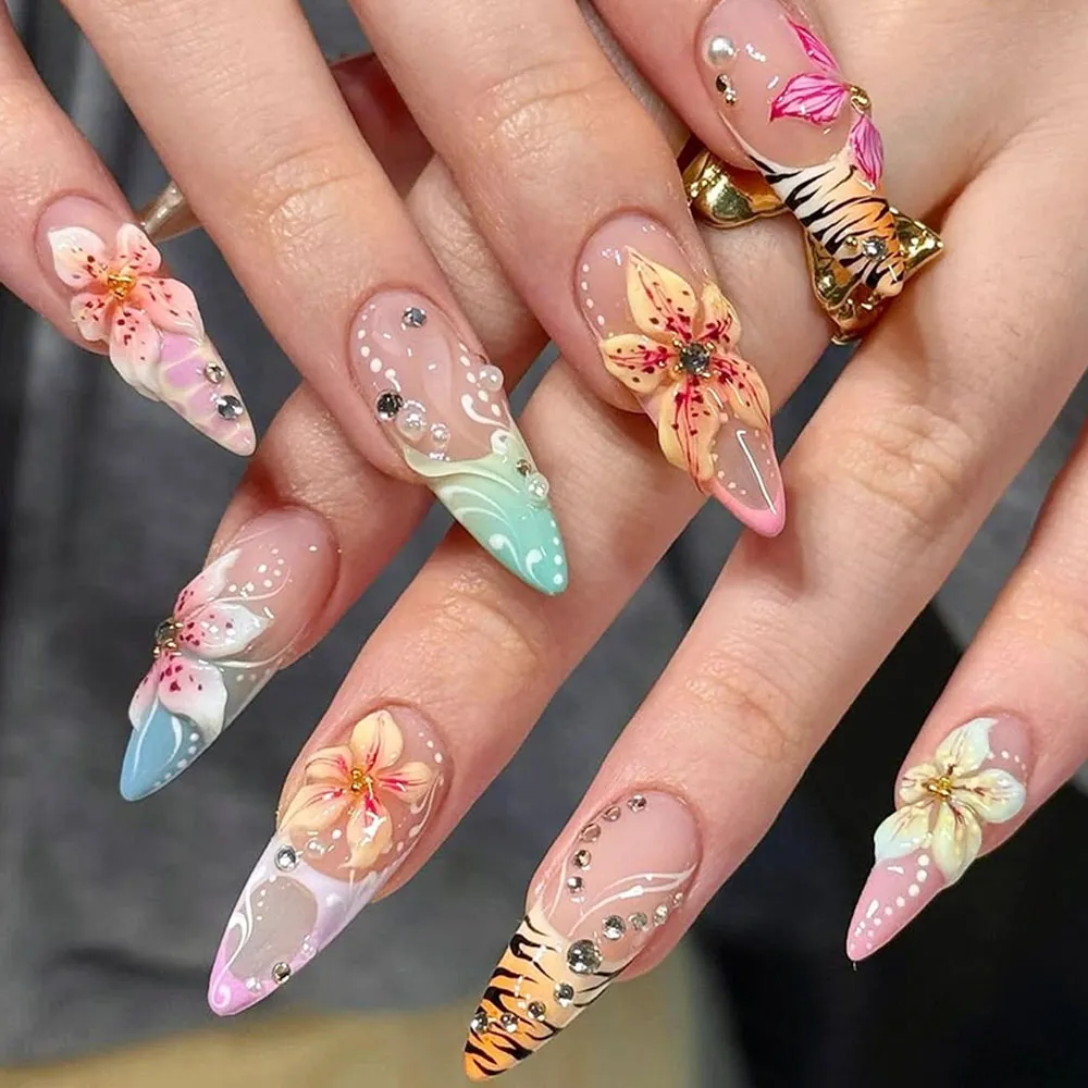 3D botanical floral press on nails worn on hand featuring hand-sculpted tiger lily and cherry blossom blooms, tiger stripe accent, pearl dots, gold bead details, and sheer iridescent bases