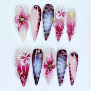 Dark botanical 3D floral press on nails with hand-sculpted magenta blooms, white 3D flowers, purple swirl calligraphy, gold shell charms, and deep burgundy gradient