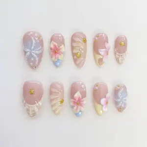 3D floral shell press on nails with pink cherry blossoms, pearlescent shell swirl texture, gold star charms, pearl dots and rose nude base for spring