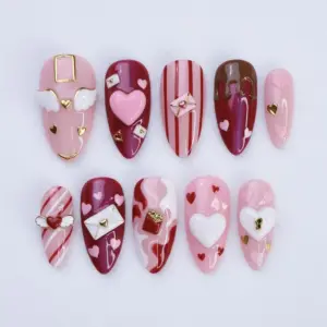 Luxury 3D Valentine's Day press on nails with winged heart charm, love letter envelope, gold crown, lipstick charm, keyhole heart and swirl marble art in pink and burgundy