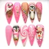 Pink Christmas press on nails with 3D hand-painted penguin characters, snowman, sleeping reindeer, white snowflakes, 3D snow swirl texture, AB rhinestones and hot pink glitter