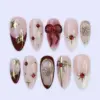Christmas press on nails with 3D bow, gold stars, snowflakes, and red rhinestones on blush pink base