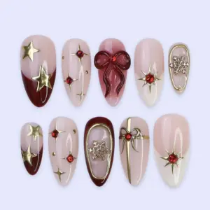 Christmas press on nails with 3D bow, gold stars, snowflakes, and red rhinestones on blush pink base