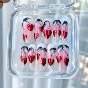 Chrome red heart press on nails with black silver vine swirl art and glitter tips displayed in a clear acrylic nail box