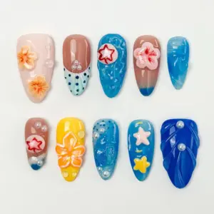 Colorful summer press on nails with 3D coral hibiscus blooms, orange hibiscus on yellow base, red star bubble dome on aqua gel texture, pastel star charms, pearl beads, and deep cobalt blue wave relief nail in a multicolor beach fake nail set