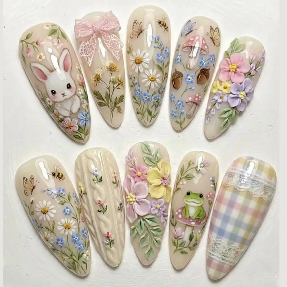 Cottagecore press on nails with hand-painted white bunny, butterflies, bees, mushrooms, forget-me-nots, 3D sculpted flowers, frog on mushroom, lace bow and pastel gingham on warm cream bases