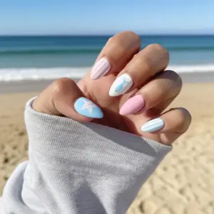 Cute pastel ocean press on nails in pink and blue with stripe pattern, starfish and fish illustration worn at the beach