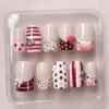 French Tip Bow Stripe Press On Nails - Valentine Fake Nails | EV77 7 Short French tip Valentine's Day press on nails with bow charm, stripe, polka dot, plaid, scrollwork swirl and heart designs in red pink and nude displayed in a clear nail box