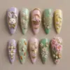 Elegant Easter press on nails with 3D bunny in gold frame, flower basket, Happy Easter script, gold egg charms, pearl cross, cherry blossoms and baby chicks on pastel lilac mint green pink and yellow bases