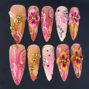 Hot pink and coral orange ombré press on nails with 3D fuchsia and golden yellow floral blooms, clustered gold ball beads, white swirl brushstrokes, gold vine lines, silver rhinestones, and dark wine dot accents on long summer fake nails