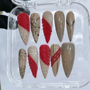 Red and mocha Christmas press on nails with 3D cable knit texture, white snowflakes, gold geometric Christmas tree outline and champagne glitter finish in clear nail box