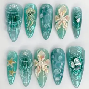 Teal chrome mermaid press on nails with 3D jellyfish charm, iridescent floral bloom, pearl beads, raw crystal gems, gold starfish, and hand-painted ocean wave art on long fake nails
