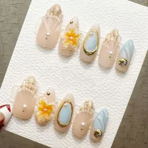 Nude pearl press on nails with sculptured translucent shell fan relief, gold-framed oval abalone stone with pearl accent, 3D golden yellow floral bloom with pearl center, textured gold scallop shell charm, soft aqua wave texture nail, and gold micro-bead accents on elegant summer fake nails