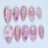 Pink aurora chrome press on nails with 3D white floral bloom and crystal bead center, translucent pink shell fan relief with fuchsia stripes, iridescent AB bubble gems, fuchsia star charms, rose gold teardrop wire frame with floating pearl, and pink starfish ocean texture on summer fake nails