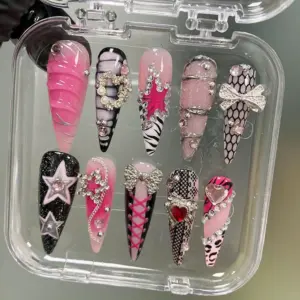 Pink black Y2K press on nails in clear box with rhinestone bow, star chain charm, corset lace design, crystal heart, zebra print, honeycomb mesh, and glitter star details