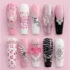 Pink glam Y2K press on nails set with 3D butterfly, cherry, crown, leopard print, rhinestone chain, and black glitter details