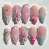 Blush pink press on nails with sculptured shell fan relief in pink and aqua, 3D fuchsia floral bloom with gold center charm, embossed pink flower, bubble gem accents in coral and teal, and gold starfish charm on summer fake nails