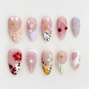 Bold summer press on nails with 3D pink floral blooms on zebra stripe and lavender shell base, glossy red cherry charm, gold starfish, blue bubble gel droplet nail, red flower on leopard print, starburst line art, iridescent petal flower on tiger stripe yellow, and translucent shell fan with pink dot accents on summer fake nails