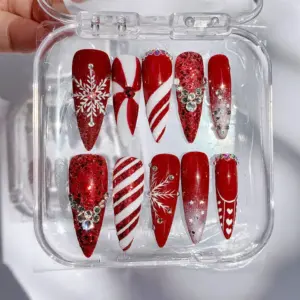 Red glitter Christmas press on nails with snowflake, candy cane stripes, rhinestone clusters, red bow and heart details in clear nail box