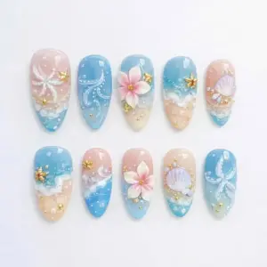 Sandy shore press on nails with hand-painted ocean wave foam on blush-pink and sky blue ombré base, 3D pink cherry blossom, lavender scallop shell, white ribbon bow, gold starfish charms, pearl micro-beads, and crystal rhinestones on summer fake nails