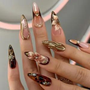 Tortoiseshell and 3D floral stiletto press on nails with gold chrome, pearl and rhinestone details on hand