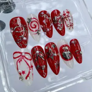 Y2K grunge Christmas press on nails with red bow, silver metallic charms, pearl beads, heart accent and swirl brushstroke art on red and white base